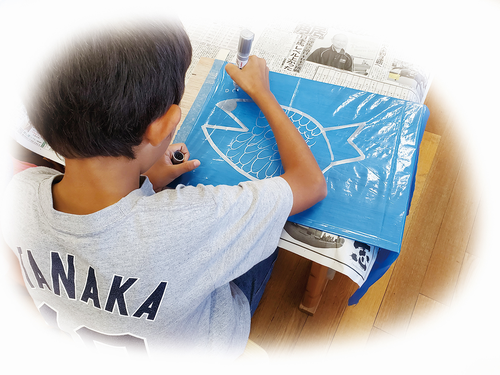 「佐賀の海」をテーマに、銀色のマーカーペンで絵を描いていく子どもたち
